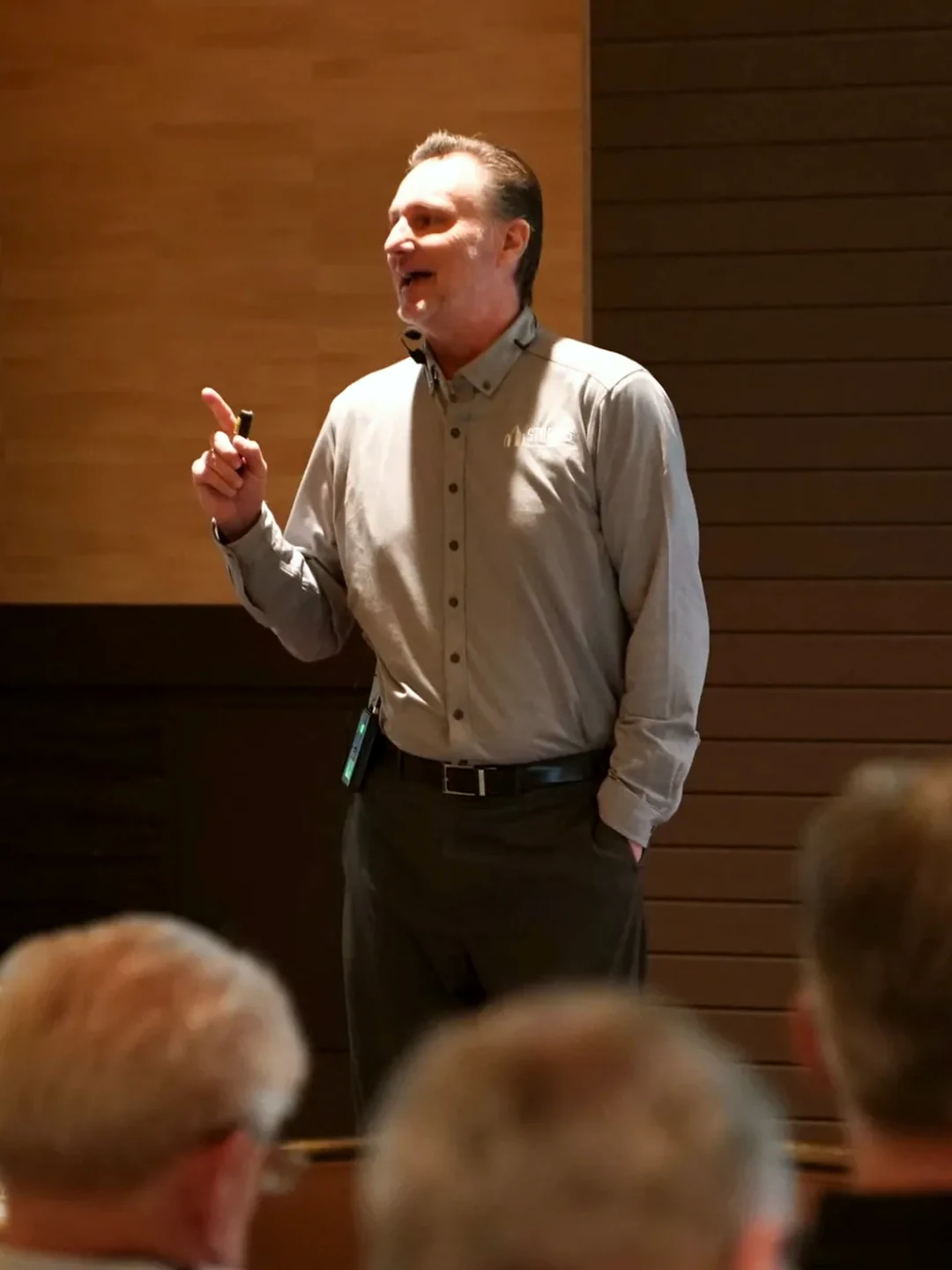 Mike Millett teaching from the front of a room, audience in the foreground