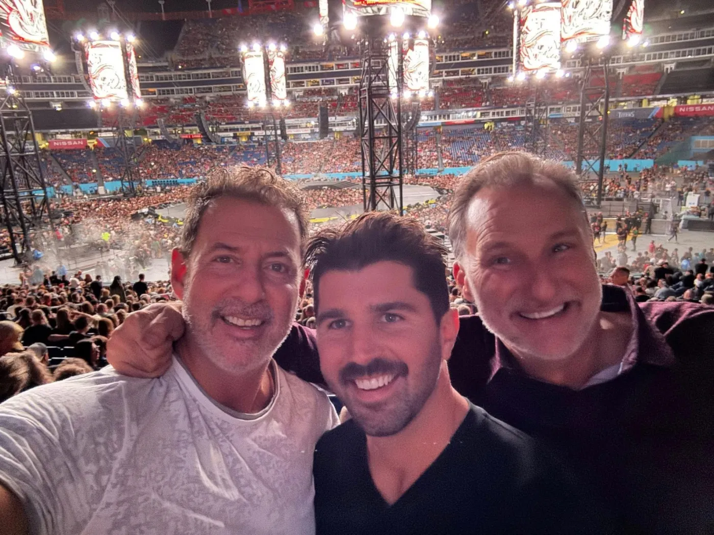 Rob Lancit, a friend and Mike Millett in the stands at a Metallica concert